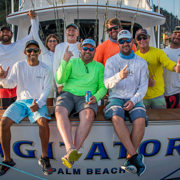 team agitator laughing at back of their fishing boat