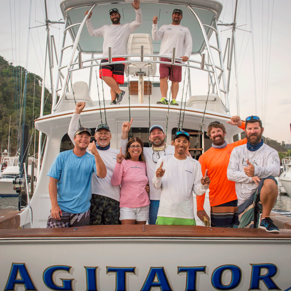 entire team of agitaor on back of boat laughing